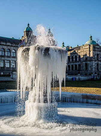 Frozen fountain on the lawn in front of a Parlament Building